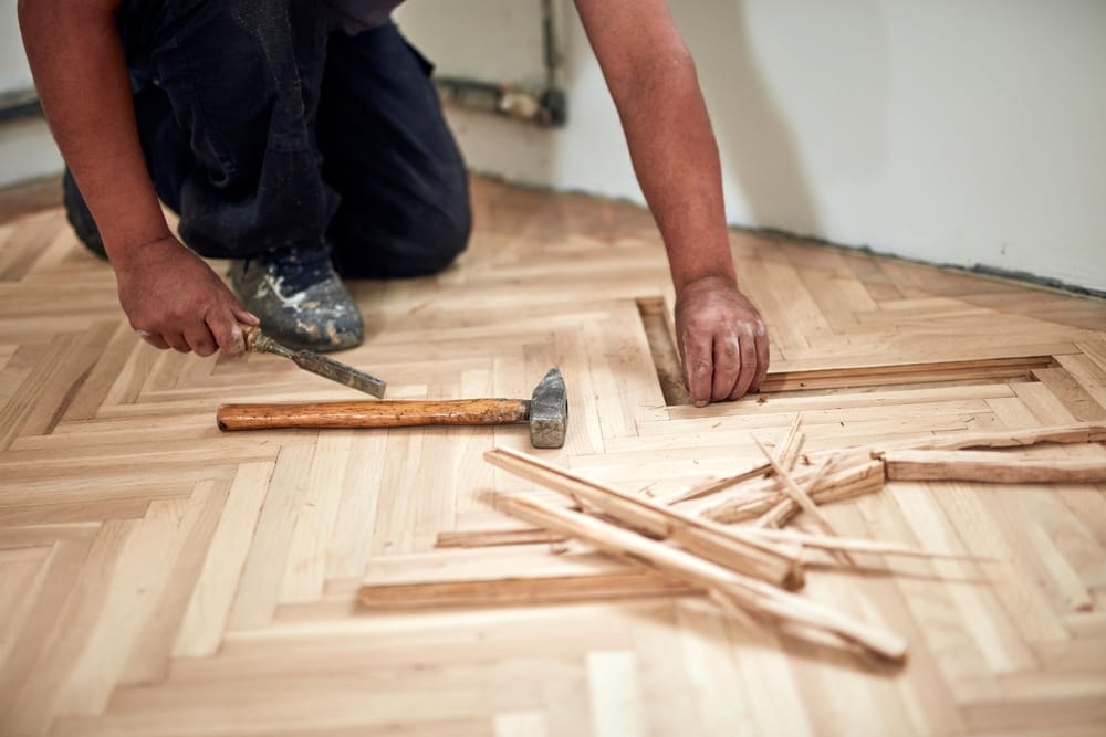 Repairman restoring old parquet hardwood floor.
