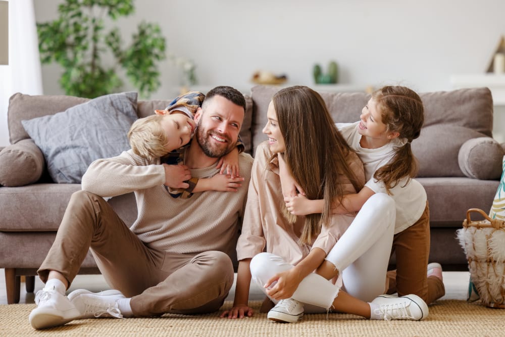 Happy family mother father and children at home on floor.